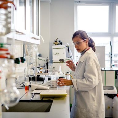 A woman at work in a research laboratory wearing goggles